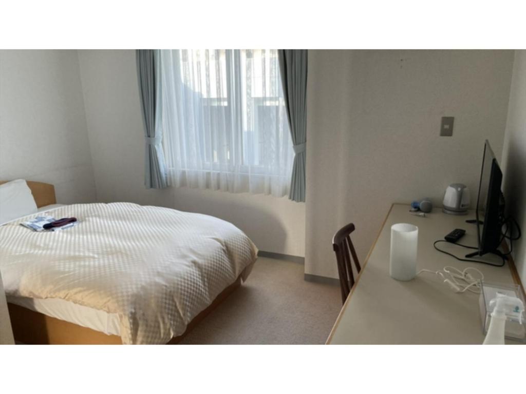 Un dormitorio con una cama y un escritorio con una computadora. en Shonan Relief - Vacation STAY 50853v, en Yokosuka