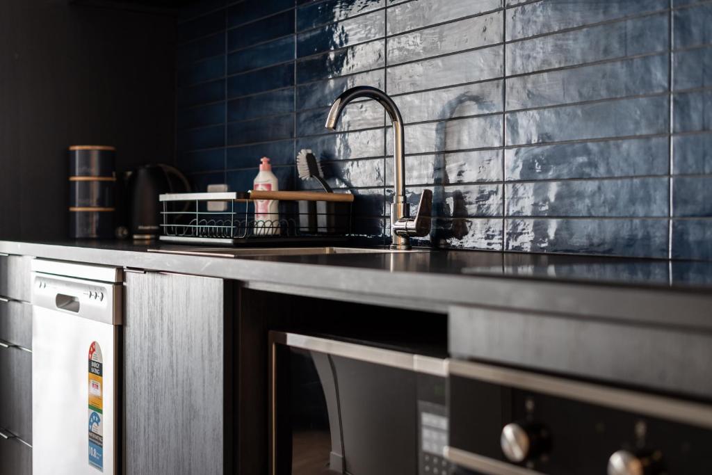 encimera de cocina con fregadero y lavavajillas en Hanover Apartment No 2 en Dunedin