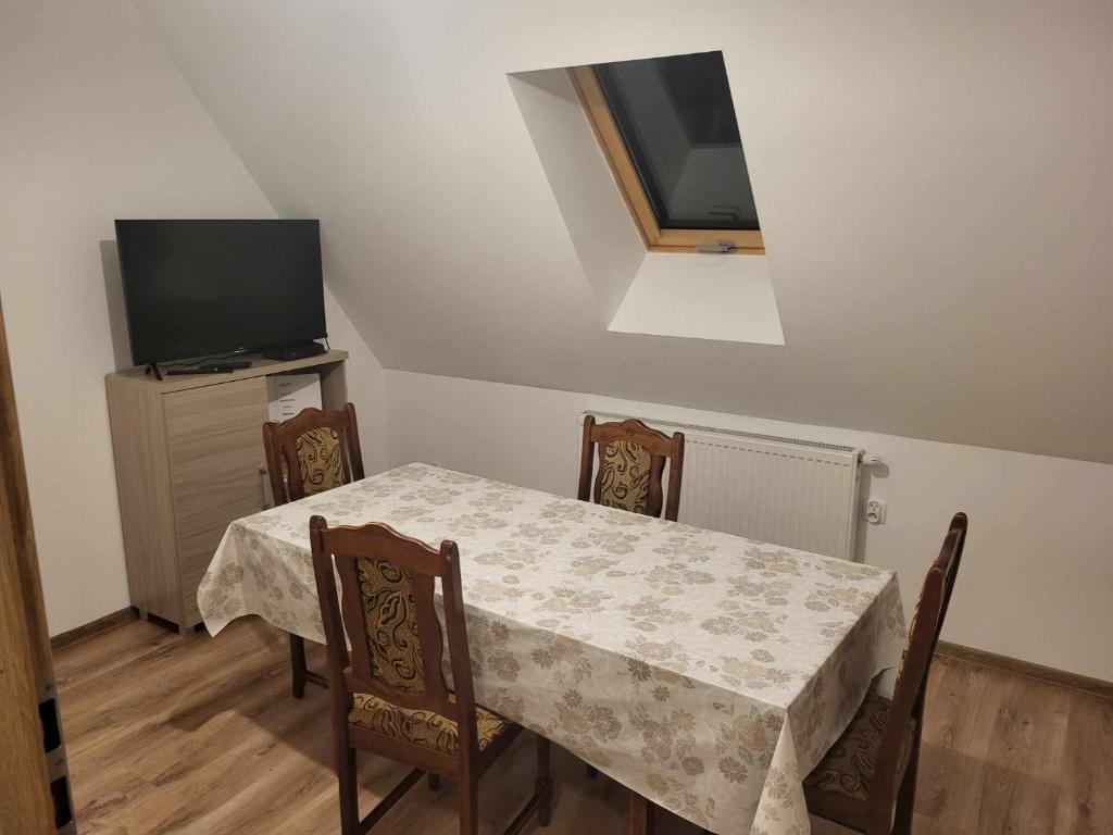 comedor con mesa y TV en Agroturystyka nad Stawem, en Międzygórze