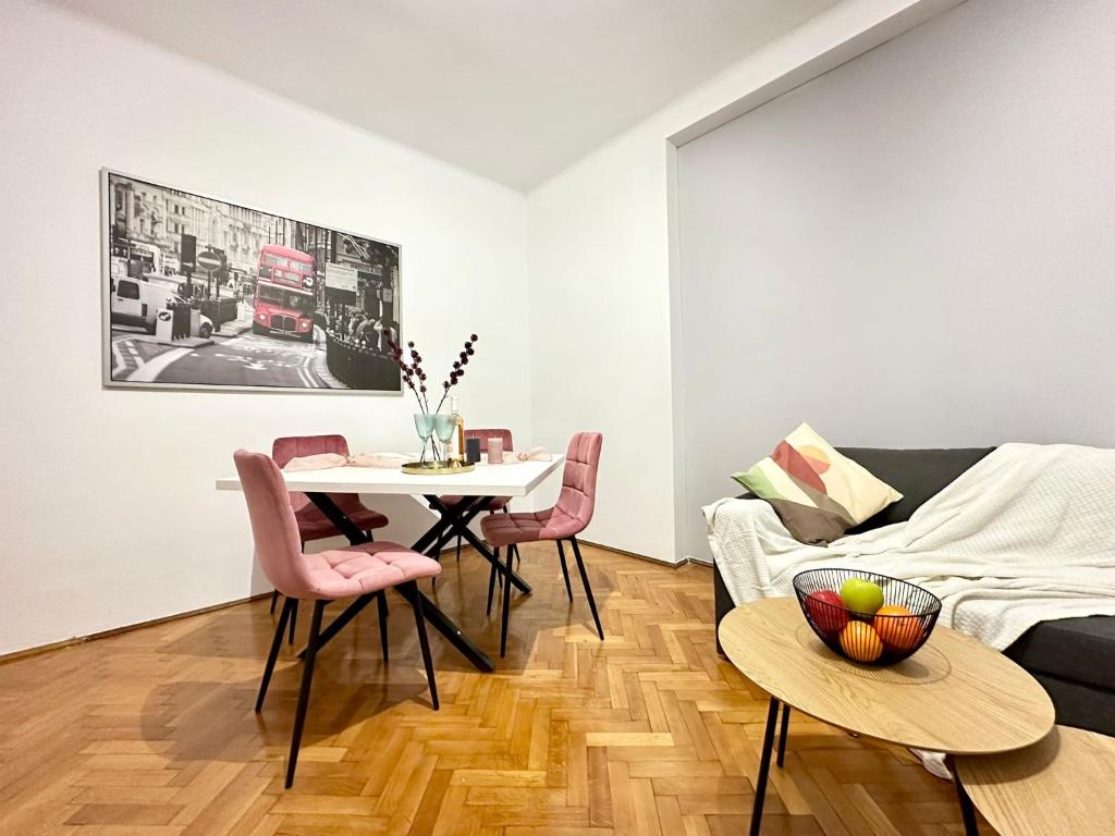 a living room with a table and chairs and a couch at Holiday Apartments PIATA ROMANA with Balcony in Bucharest