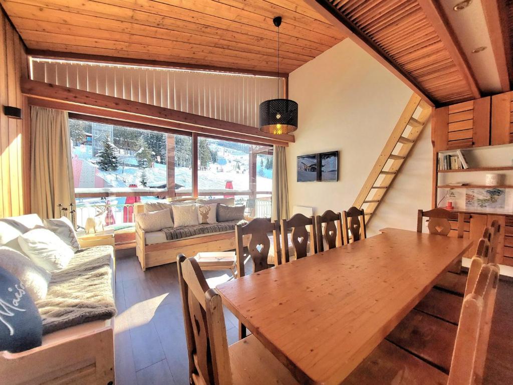 a dining room with a table and a couch at Appartement spacieux et rénové - Ski aux pieds - Balcon - Wifi - 8/9 pers - FR-1-346-553 in Arc 1800