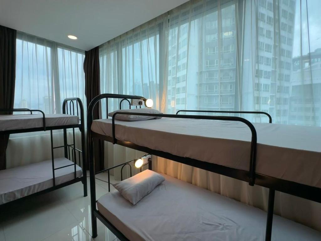 three bunk beds in a room with a window at KLCC Dorm (7 min walking to Twin Towers) in Kuala Lumpur