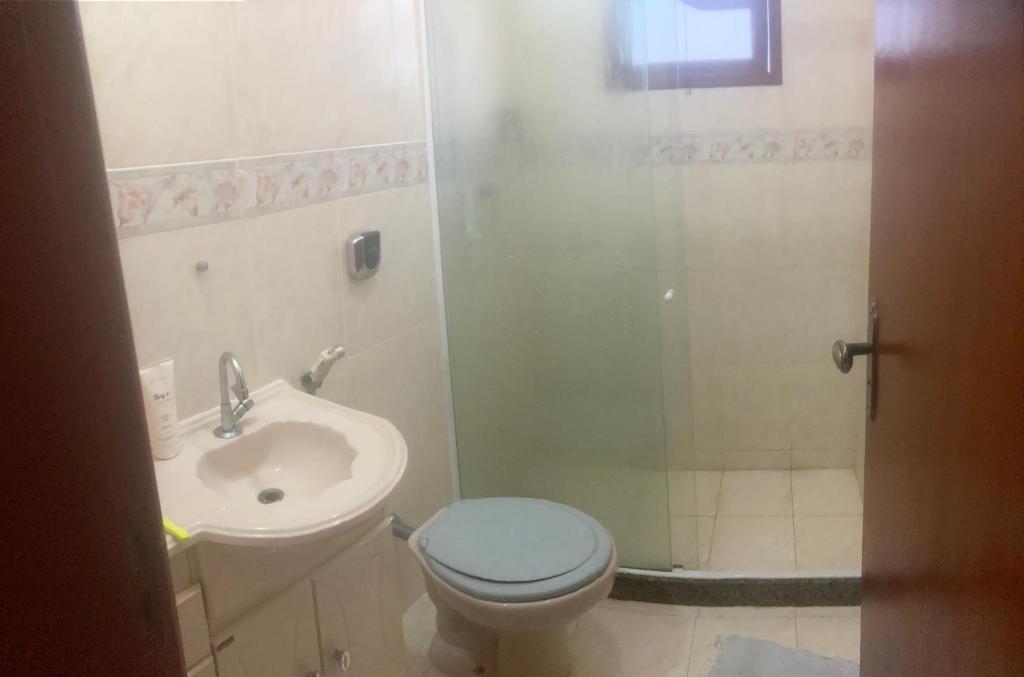 a bathroom with a toilet and a sink and a shower at Pousada do vovô in Rio das Ostras