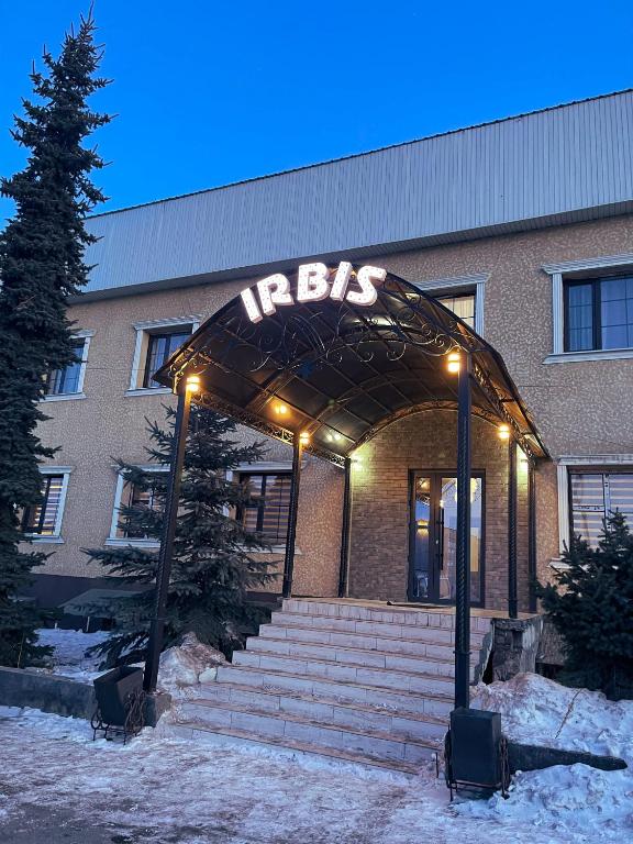 an entrance to a building with a lit up sign at Irbis Hostel in Karakol