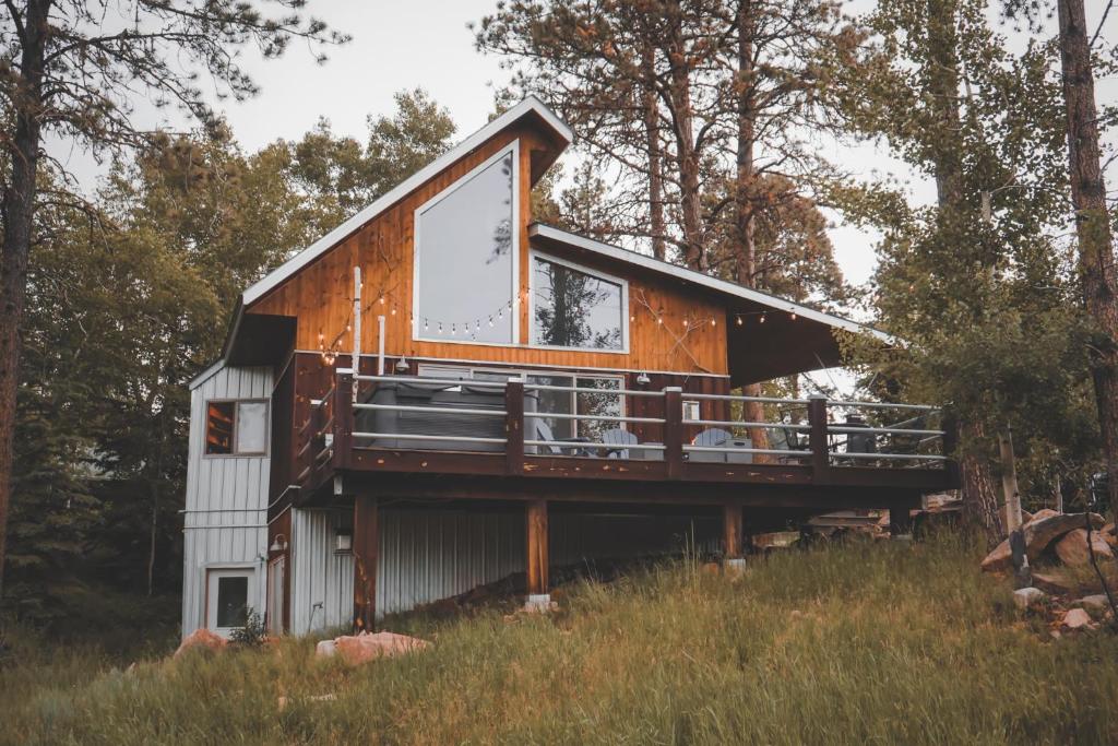 a house with a wrap around deck in the woods at Divided Sky in Lead