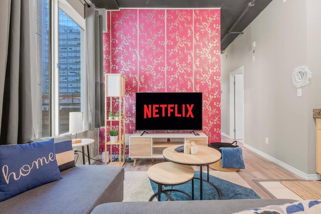 a living room with a netflix sign on a wall at Chic 2-Bedroom Apt With Arcade in Edmonton