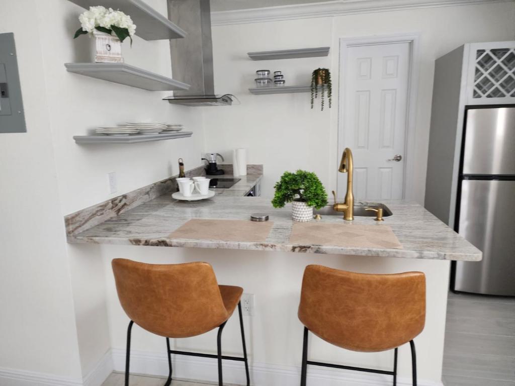 a kitchen with a marble counter top and two chairs at Studio furnished in Kissimmee