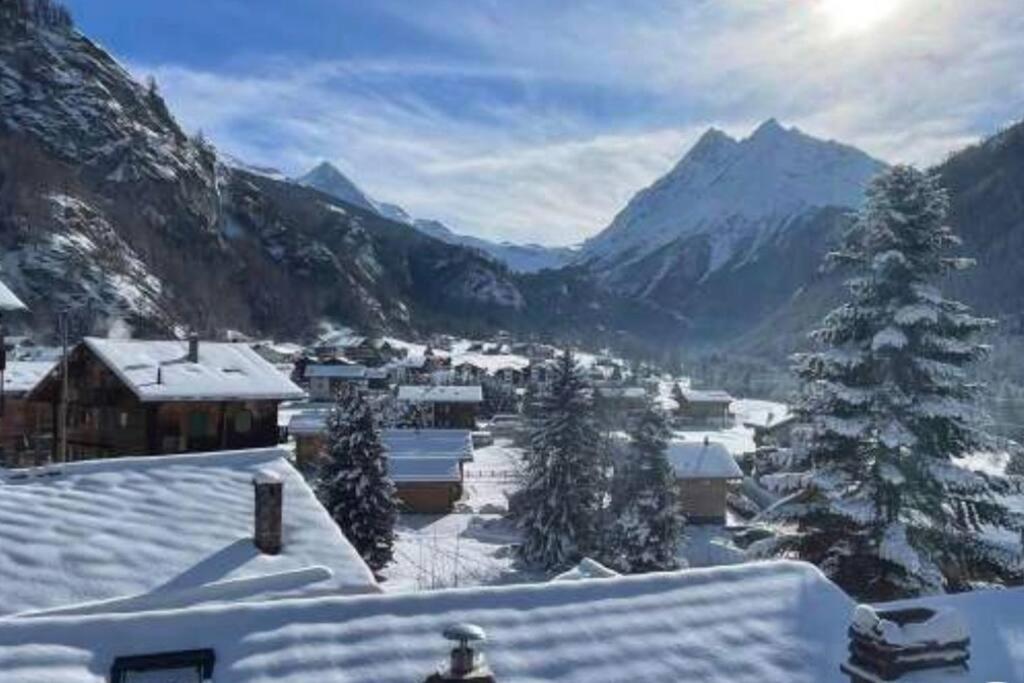 un villaggio ricoperto di neve con montagne sullo sfondo di Charme et authenticité a Evolène