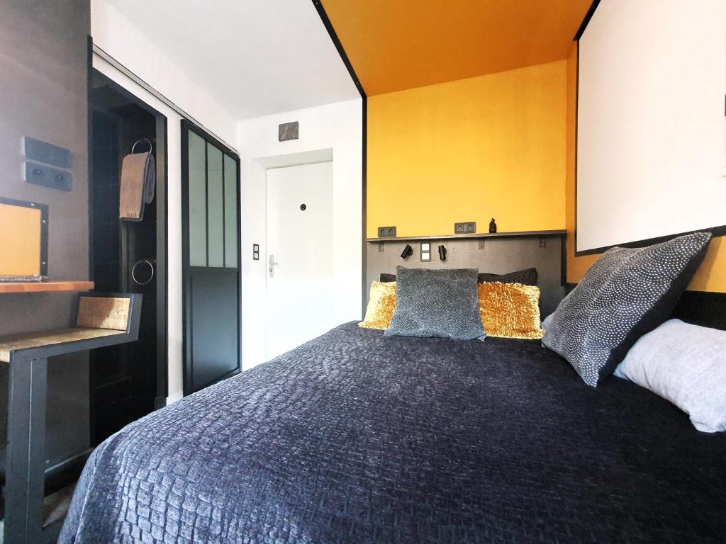 um quarto com uma cama grande e uma parede amarela em Apartment MiniSteel Loft Brotteaux Part-Dieu em Lyon