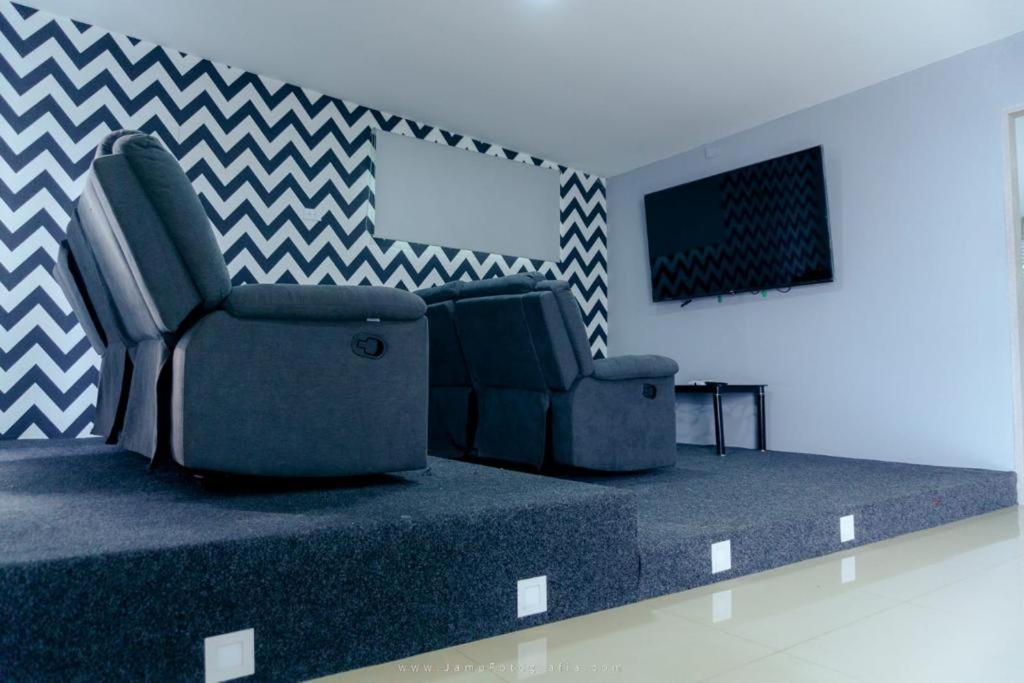 uma sala de estar com um sofá e uma televisão em Hotel Suites Lounge La Viga em Cali