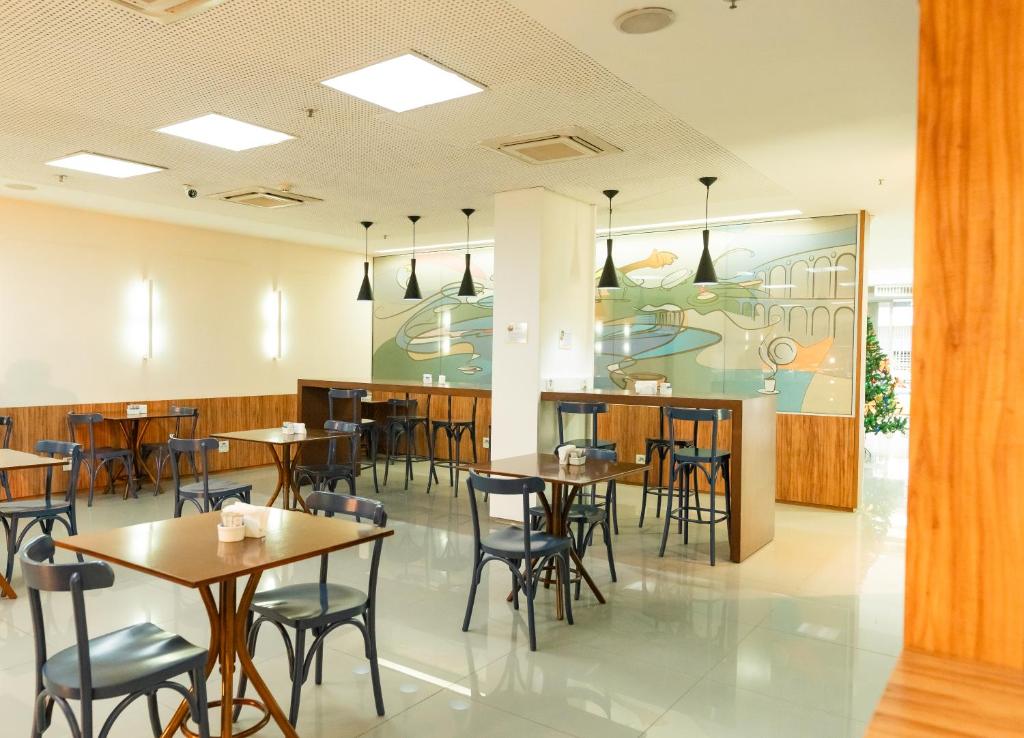 uma sala de jantar com mesas e cadeiras e um mural em Days Inn by Wyndham Rio de Janeiro Lapa no Rio de Janeiro