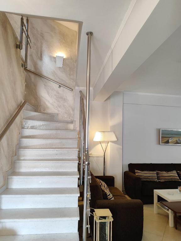 a staircase in a living room with a couch at Vasiliki house 1 in Vartholomio