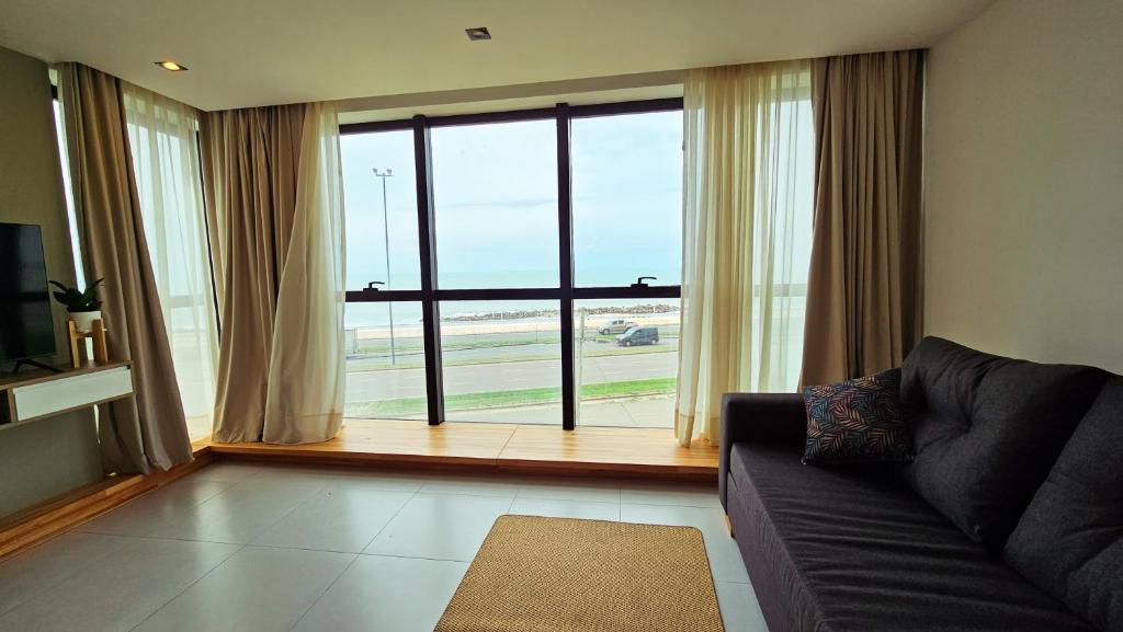 uma sala de estar com um sofá e uma grande janela em Alma de mar 2 em Mar del Plata