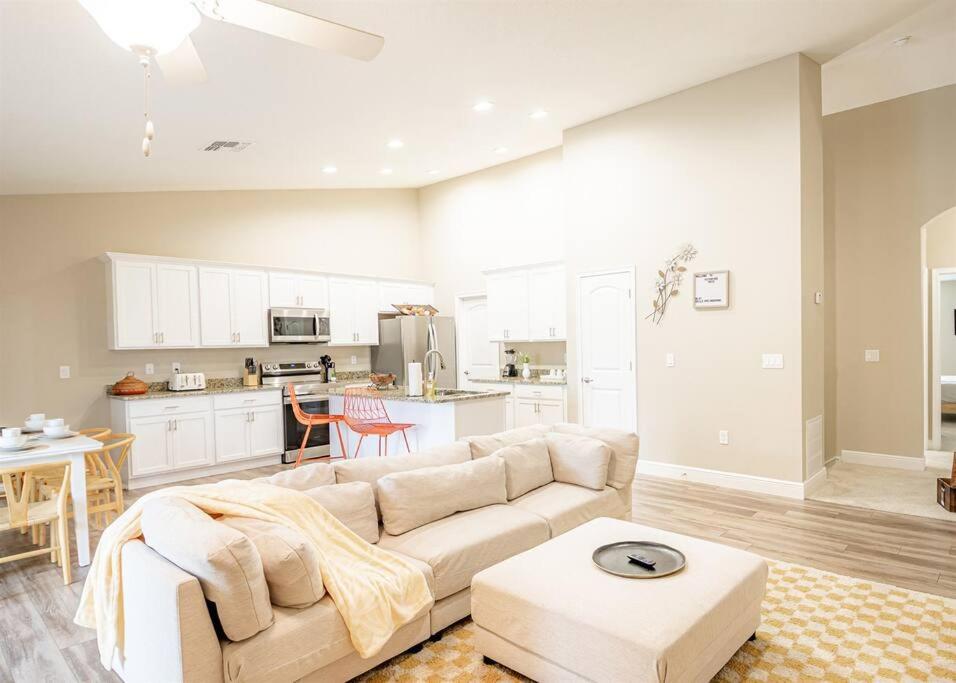 a living room with a white couch and a kitchen at OCEAN VIEW - Retro Arcade - 3 bedrooms in Daytona Beach Shores