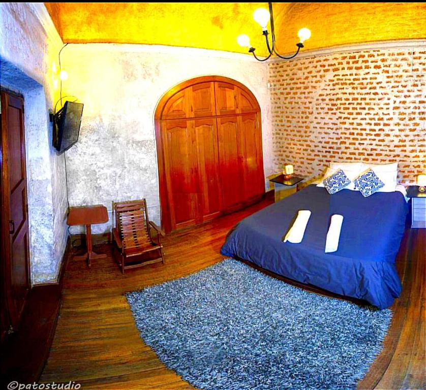 a bedroom with a blue bed and a wooden door at Bubamara Bolivar in Arequipa