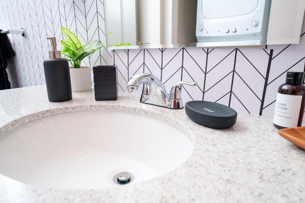 a bathroom counter with a white sink and a sink at Cozy Luxurious Loft in Downtown Memphis in Memphis