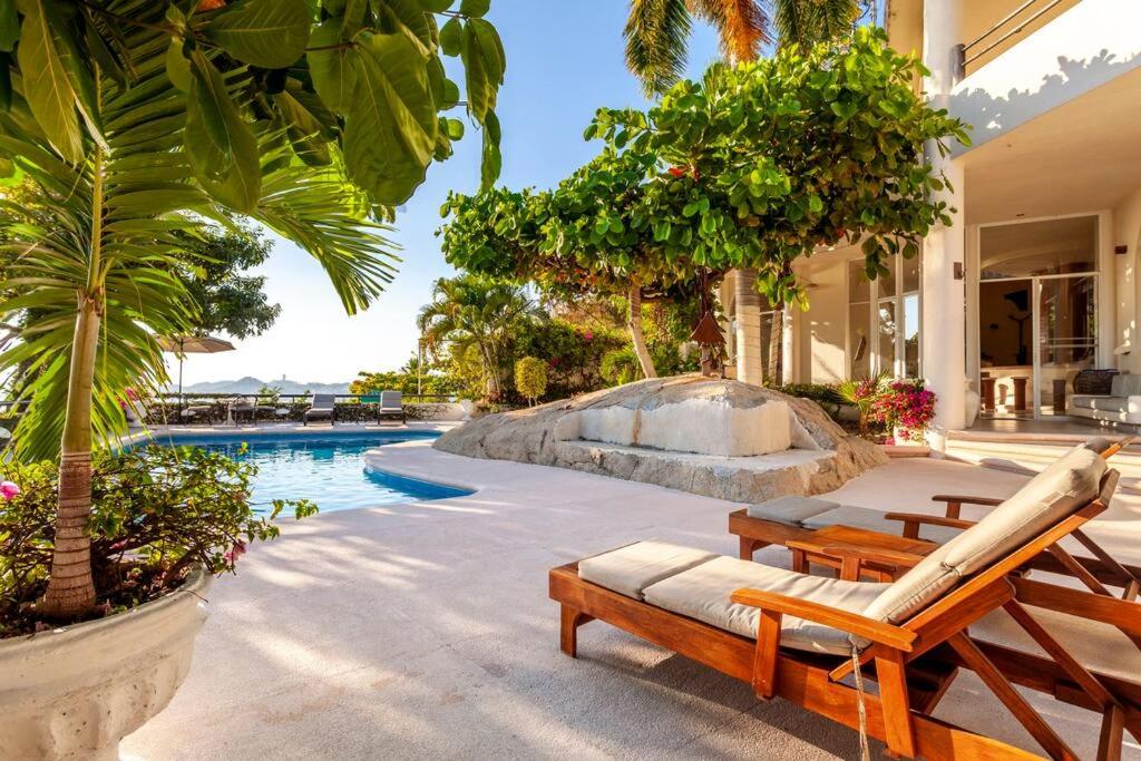 uma piscina de resort com 2 espreguiçadeiras e uma piscina em Preciosa Villa en Marina Las Brisas em Acapulco