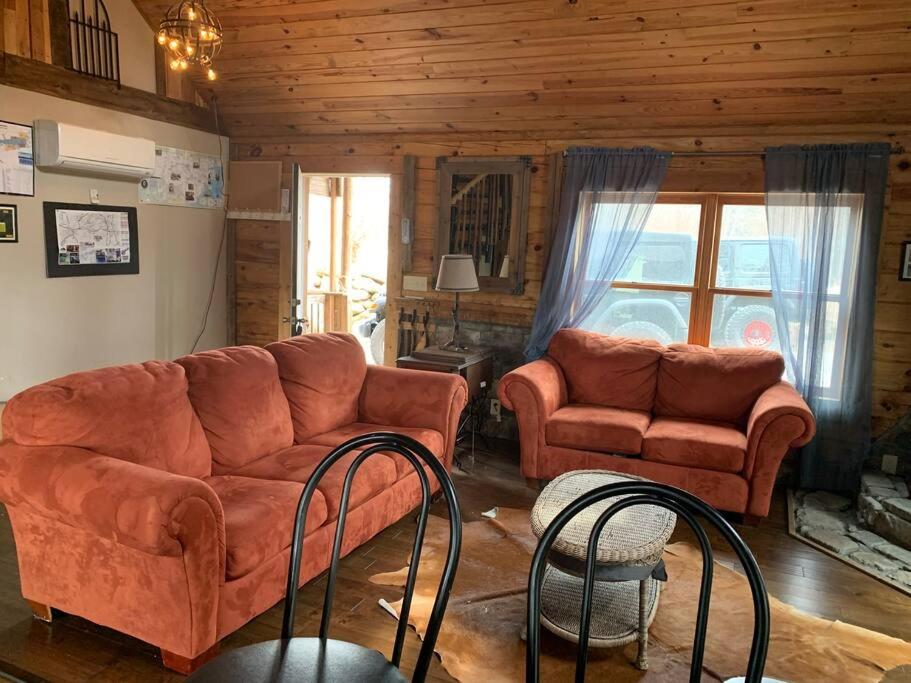 - un salon avec un canapé et deux chaises dans l'établissement Barefoot Cabin, 