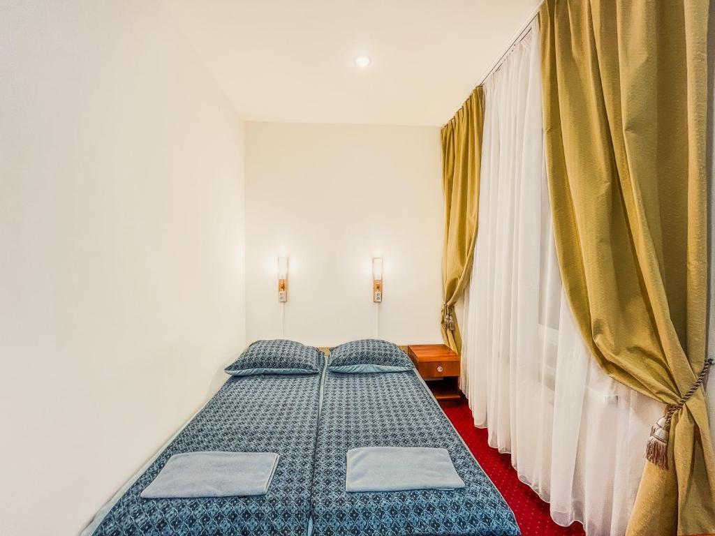 a bedroom with two beds with yellow curtains at Fry House in Warsaw