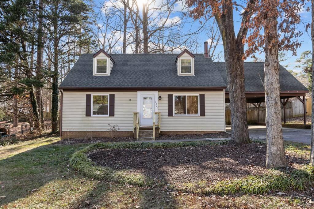 a white house with a tree in the yard at Beautifully updated home! Near downtown & NC State in Raleigh