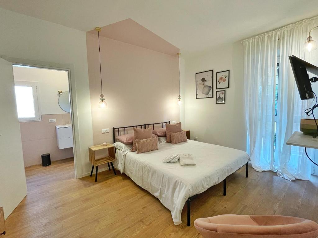 ein Schlafzimmer mit einem Bett mit weißer Bettwäsche und braunen Kissen in der Unterkunft BeHappyS Deluxe Apartment-Charming Balcony in Bologna