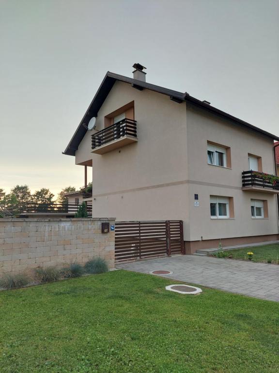 una casa grande con una valla en un patio en Apartman Ždralović, en Lipik