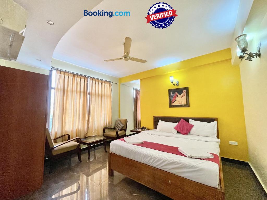 um quarto de hotel com uma cama e uma cadeira em Hotel Surya Beach inn ! PURI near-sea-beach-and-temple fully-air-conditioned-hotel with-lift-and-parking-facility em Puri