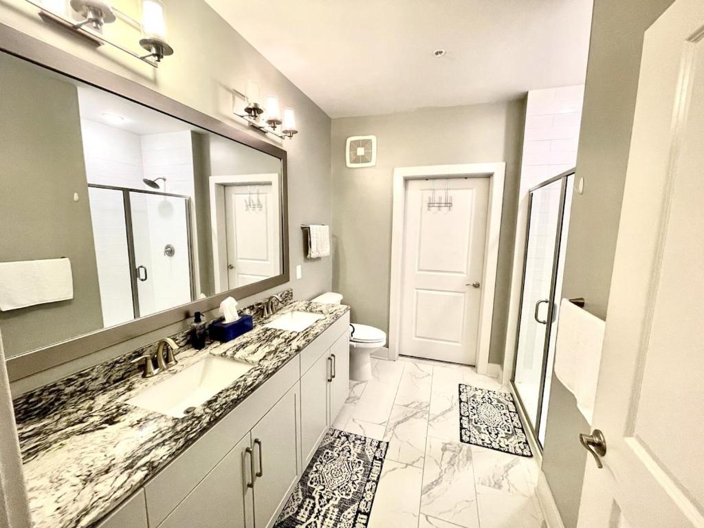 a bathroom with two sinks and a large mirror at 5-Bedroom Combined Apartment in King of Prussia! in King of Prussia