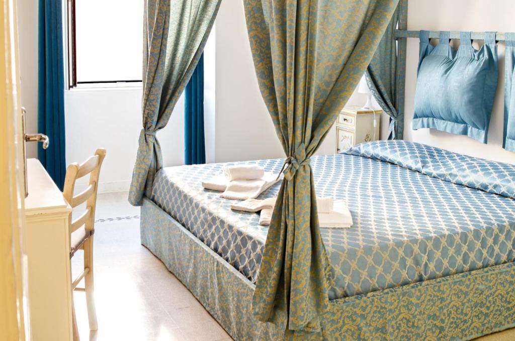 Merulana Suite Apartment في روما: غرفة نوم بسرير والستائر زرقاء