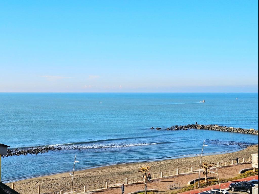 uma praia com uma cerca e o oceano em Attico Granelli di Sabbia em Lido di Ostia