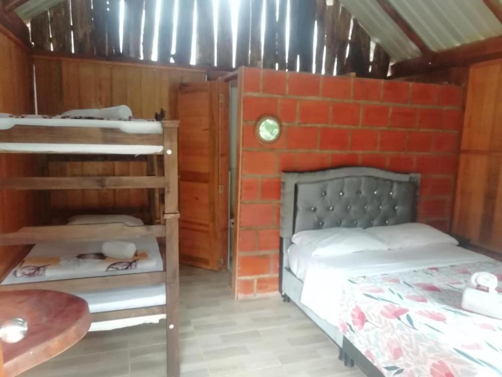 1 Schlafzimmer mit 2 Etagenbetten und Ziegelwand in der Unterkunft Hospedaje Norcasia in Norcasia