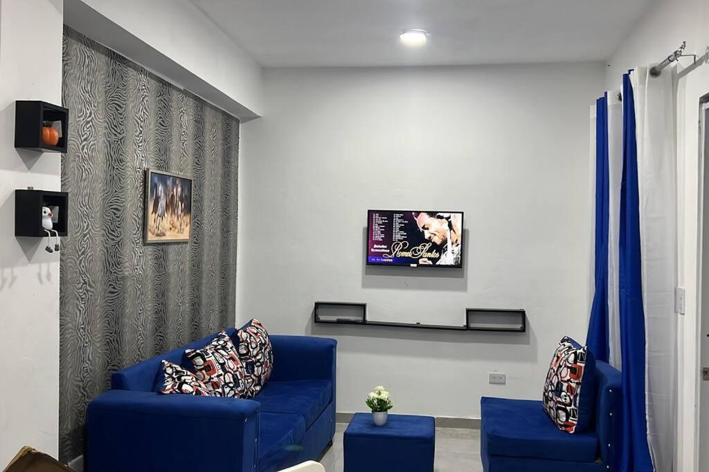 un soggiorno con divano blu e TV di Apartamento la familia 2 a Santa Bárbara de Samaná