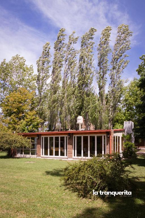 a house with a large tree in front of it at Finca La Tranquerita in San Rafael