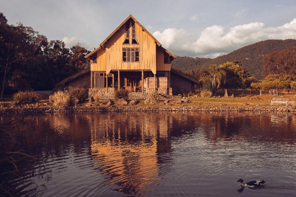 una casa antigua en un lago con un pato en el agua en Monã, en Canela