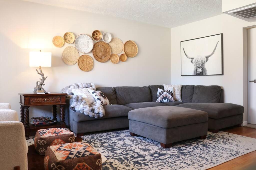 a living room with a couch and a bull on the wall at Cowboy Den-Hot Tub-Game Room-Pet Friendly-No Pet Fees! in Albuquerque