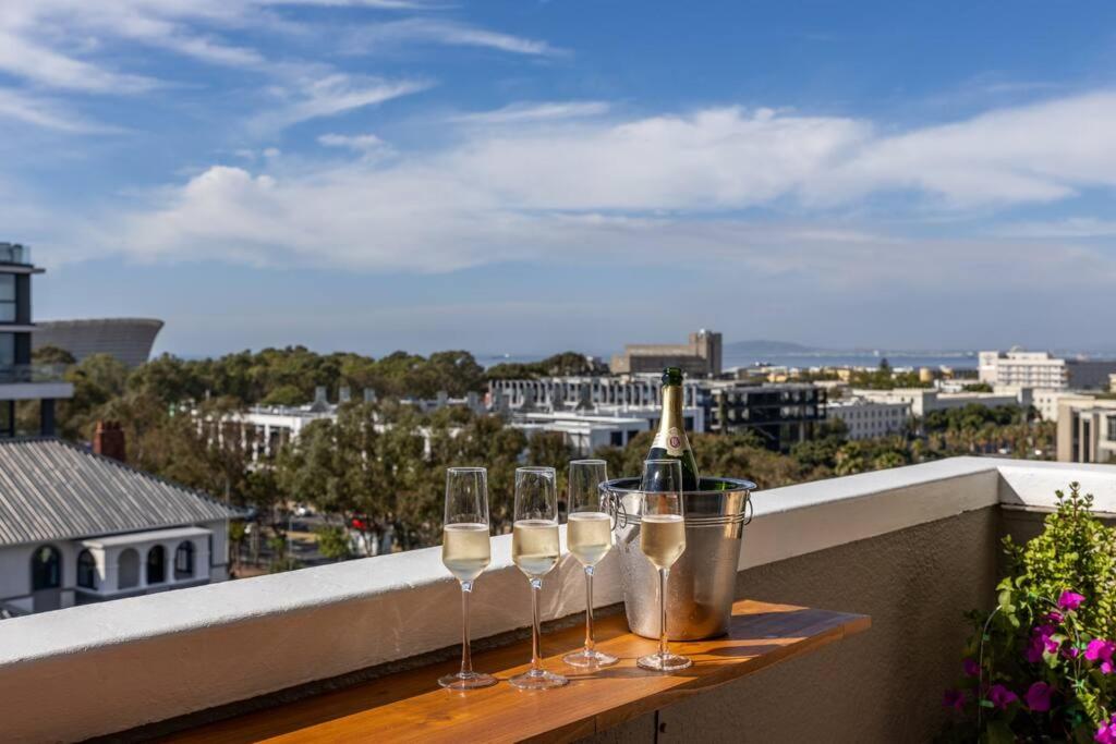 a table with wine glasses on top of a balcony at Greenpoint Emerald in Cape Town
