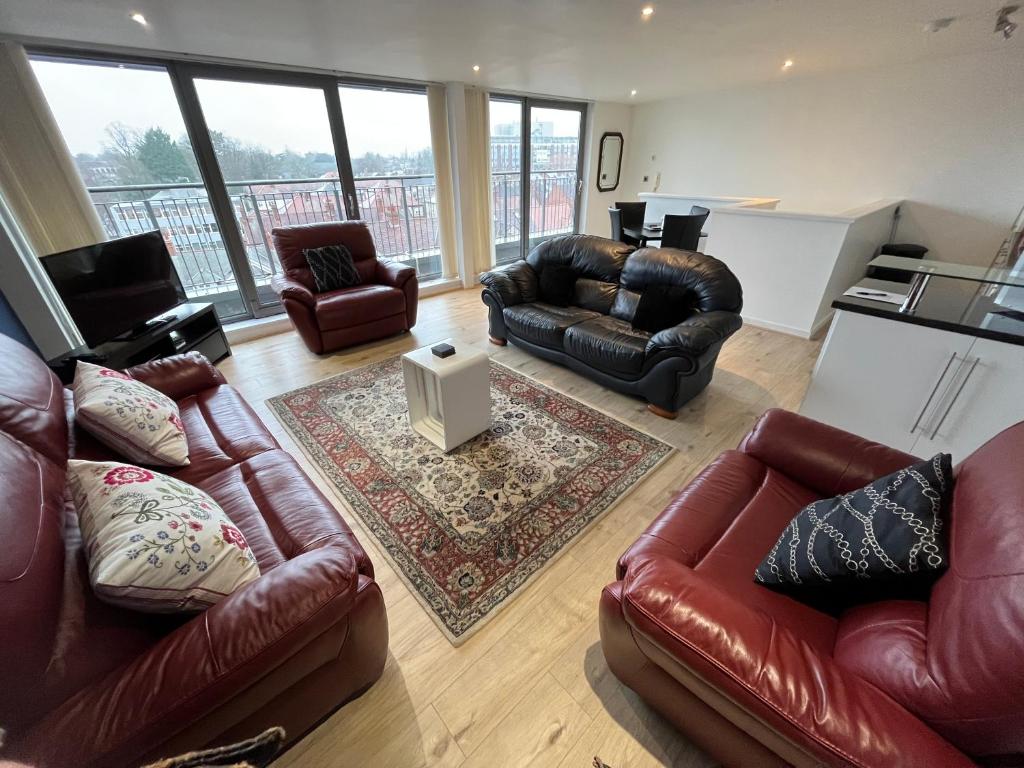 a living room with leather couches at Central Darlington Large Penthouse Apartment in Darlington