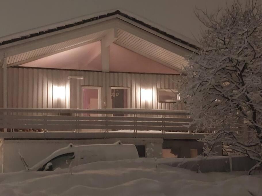 een huis bedekt met sneeuw met een auto ervoor bij Seaside in Tromsø