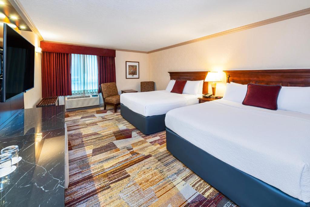 a hotel room with two beds and a flat screen tv at Royal Canadian Lodge in Banff
