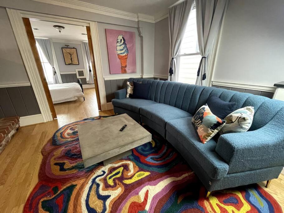 ein Wohnzimmer mit einem blauen Sofa und einem Teppich in der Unterkunft Stupendous Apartment Steps From the Capitol! in Washington