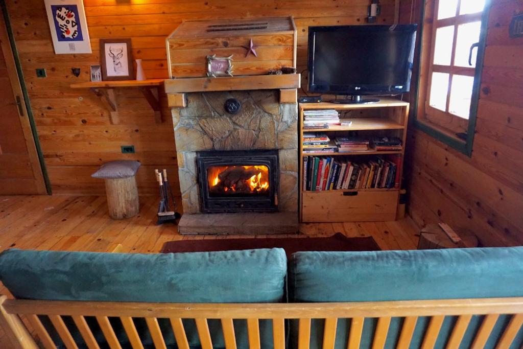 ein Wohnzimmer mit einem Sofa und einem Kamin in der Unterkunft Guest House Montana in Kopaonik