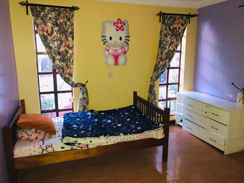 um quarto com uma cama com uma parede Hello Kitty em weekend getaway fully furnished em Kiserian