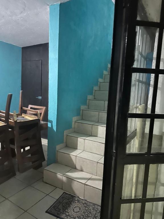 a staircase in a room with a table and a door at Habitación privada in Guadalajara