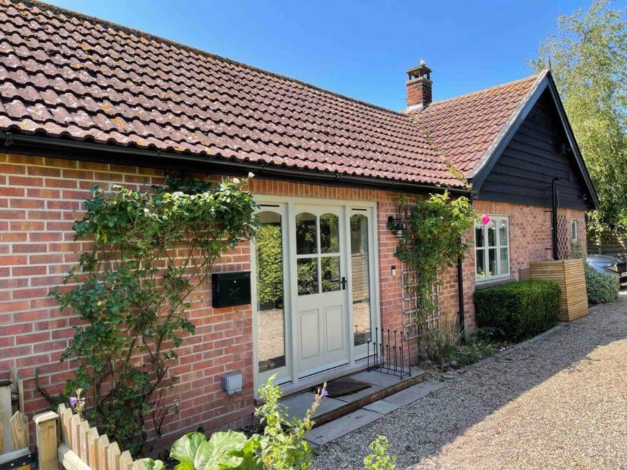 a small red brick house with a white door at Lovely quiet cottage Sleeps 4 adults, 4 children, Dog Friendly in Cley next the Sea