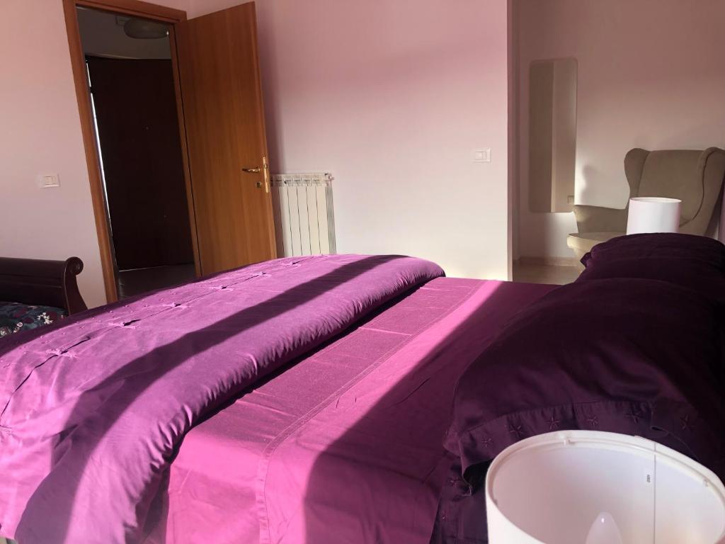 托爾托雷托的住宿－Casa Vacanze 365 - blu，铺在床上的紫色毯子