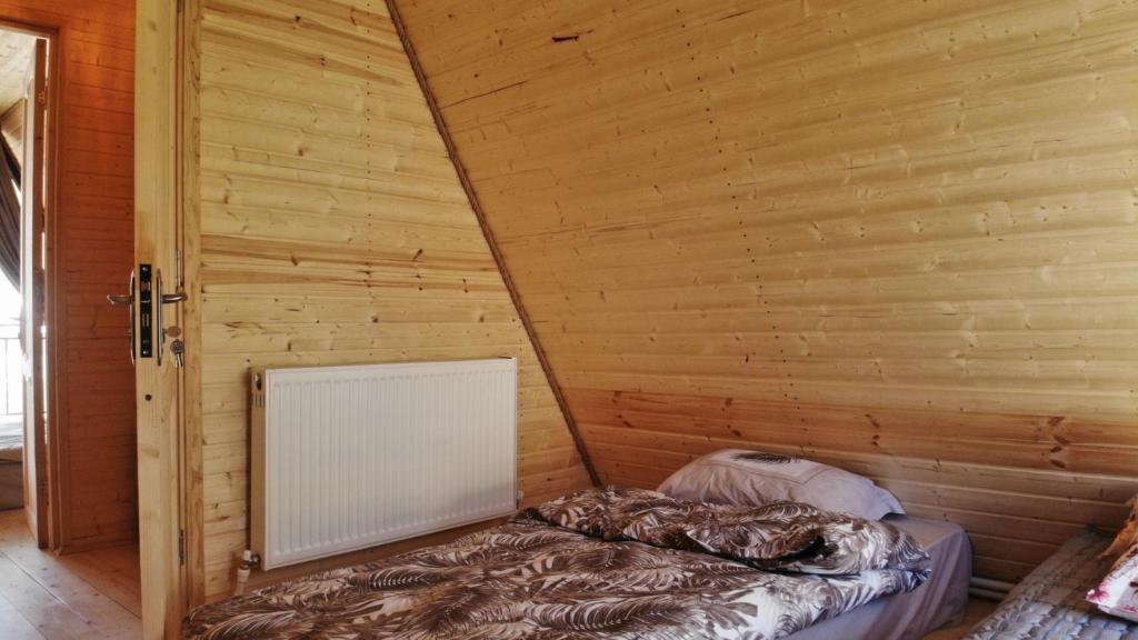 Ce lit se trouve dans un dortoir doté d'un mur en bois. dans l'établissement Cottage 360°, à Surami
