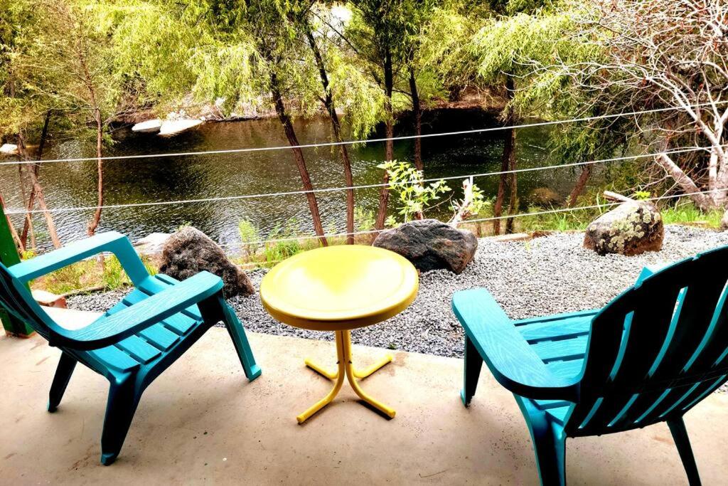 a patio with three chairs and a yellow table and a table at Retro Casita on the River! only 1 min to SNP gate! in Three Rivers