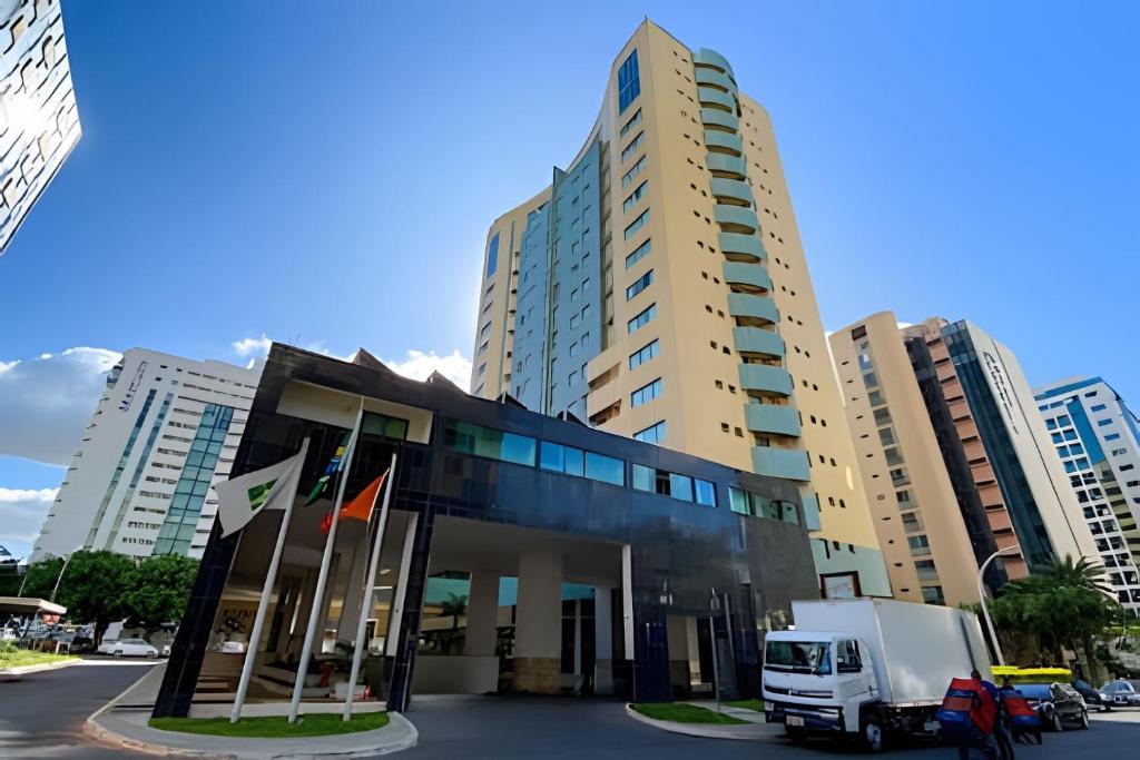 巴西利亞的住宿－Hotel Lets Ideia Brasília - Ozped Flats，停在高楼前的卡车