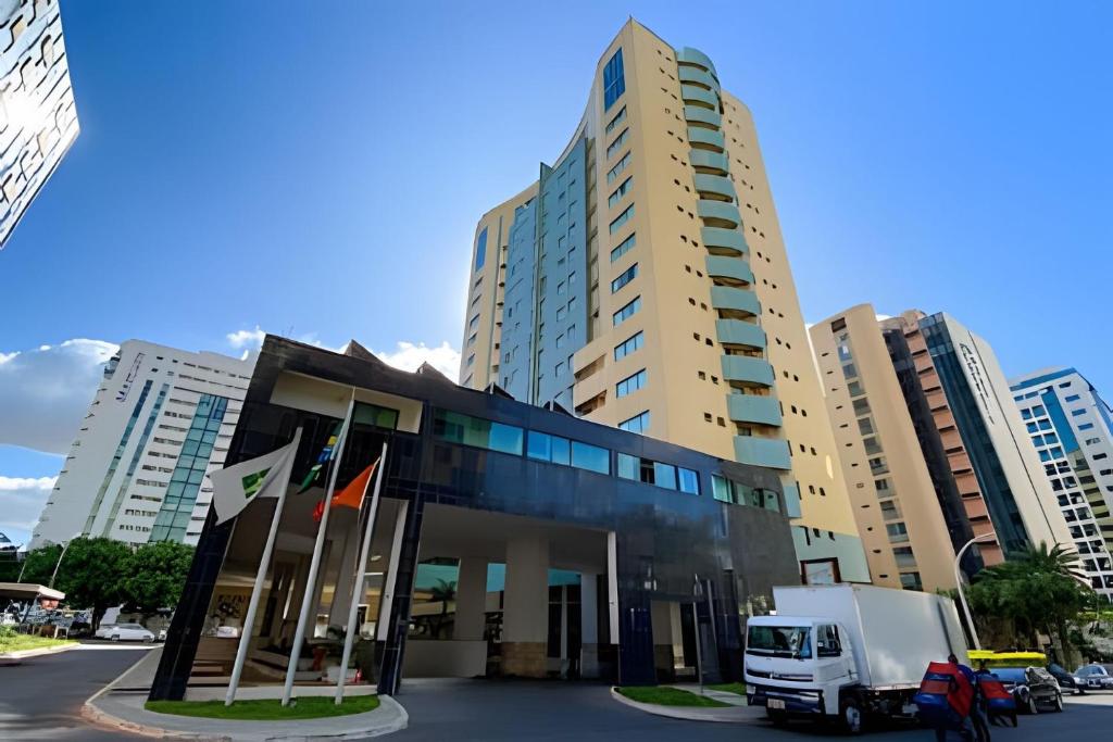 un camion parcheggiato di fronte a un palazzo alto di Hotel Lets Ideia Brasília - Ozped Flats a Brasilia