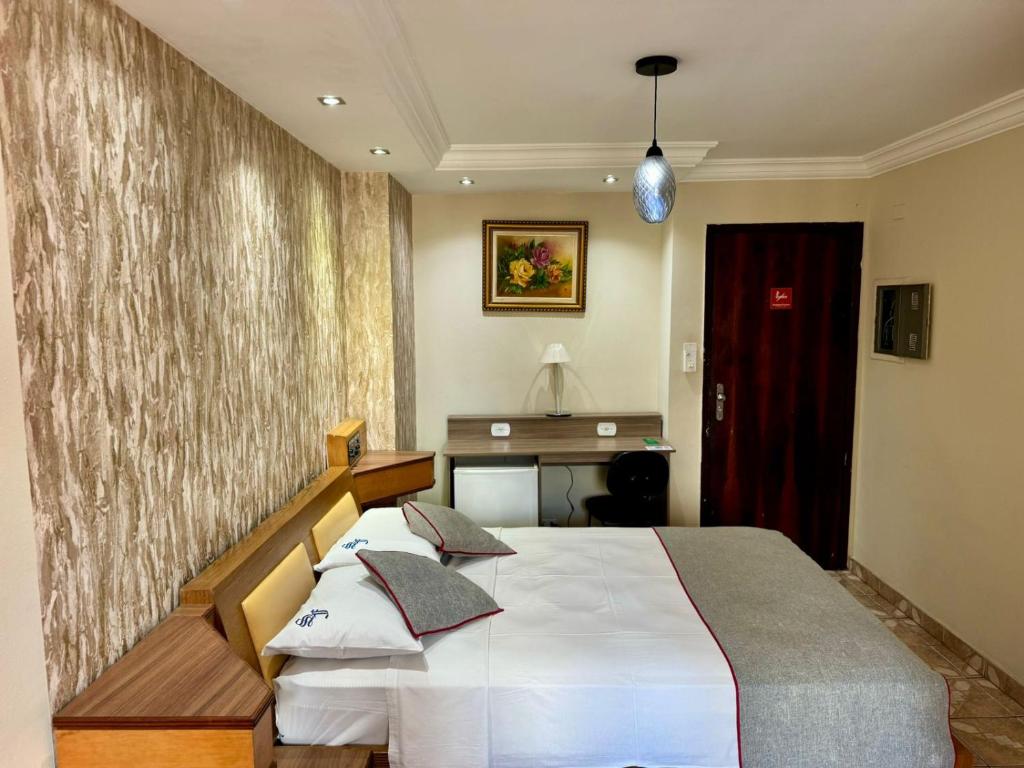 a bedroom with a bed and a desk in it at San Francisco Plazza in São Paulo